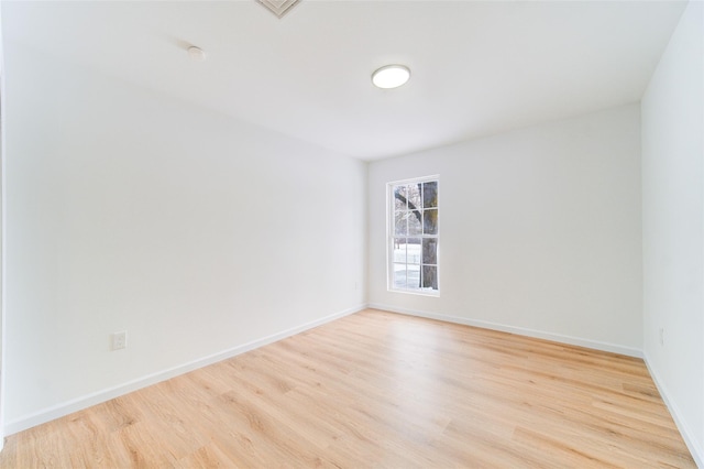 empty room featuring light wood finished floors and baseboards