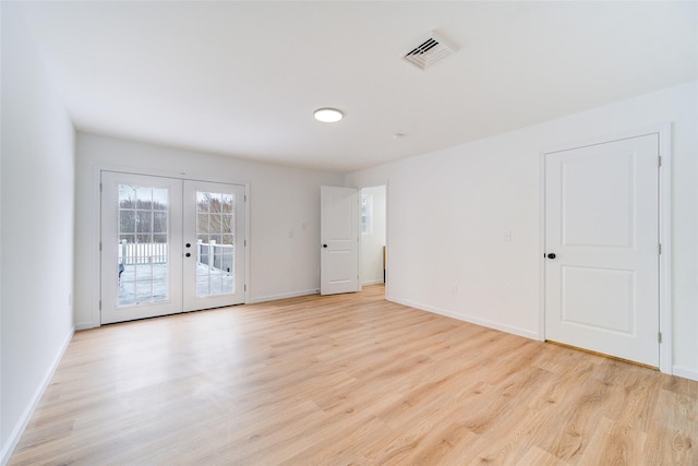 spare room with light wood-type flooring, baseboards, visible vents, and french doors