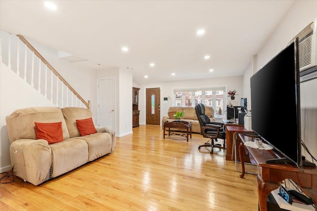 living area with recessed lighting, light wood-type flooring, baseboards, and stairs