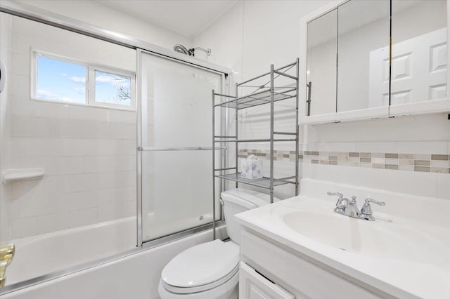 bathroom featuring toilet, vanity, and shower / bath combination with glass door