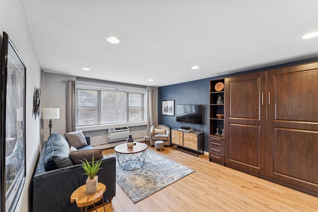 living area with a baseboard heating unit, recessed lighting, and light wood-style floors