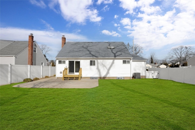 back of house featuring entry steps, a yard, and a patio