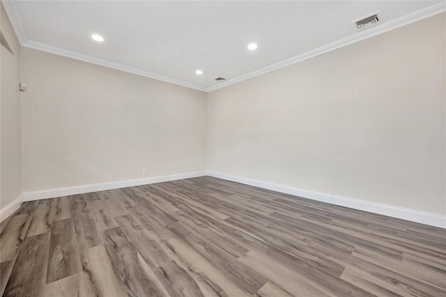 unfurnished room featuring light wood-type flooring, baseboards, visible vents, and ornamental molding