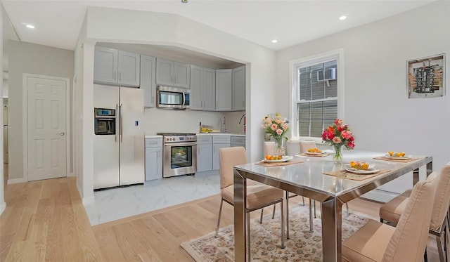 kitchen featuring recessed lighting, gray cabinetry, stainless steel appliances, light wood-style floors, and light countertops