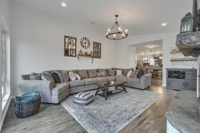 living room with recessed lighting, wood finished floors, and an inviting chandelier