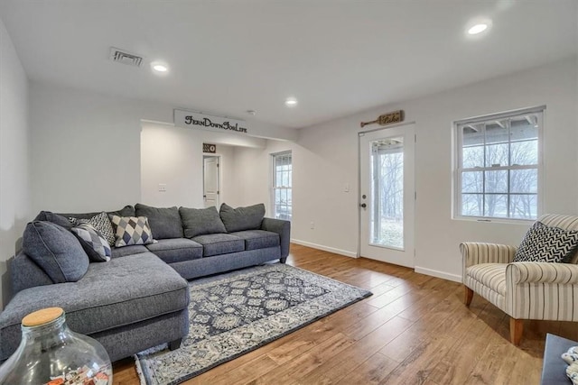 living room featuring baseboards, wood finished floors, visible vents, and recessed lighting