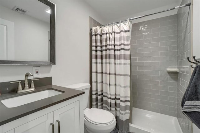 full bathroom featuring toilet, a stall shower, visible vents, and vanity