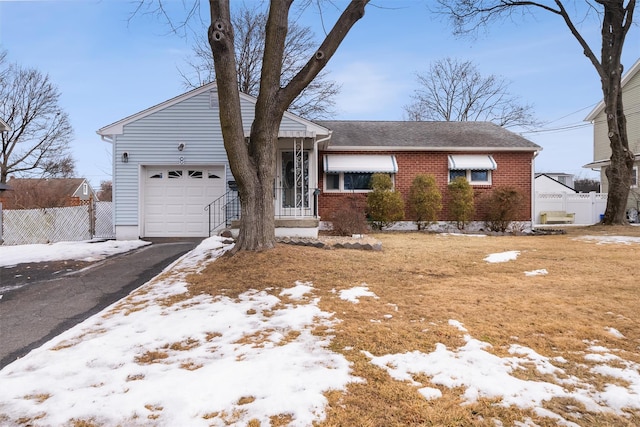 ranch-style home featuring brick siding, an attached garage, fence, and aphalt driveway