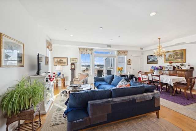 living room with recessed lighting, visible vents, an inviting chandelier, and wood finished floors