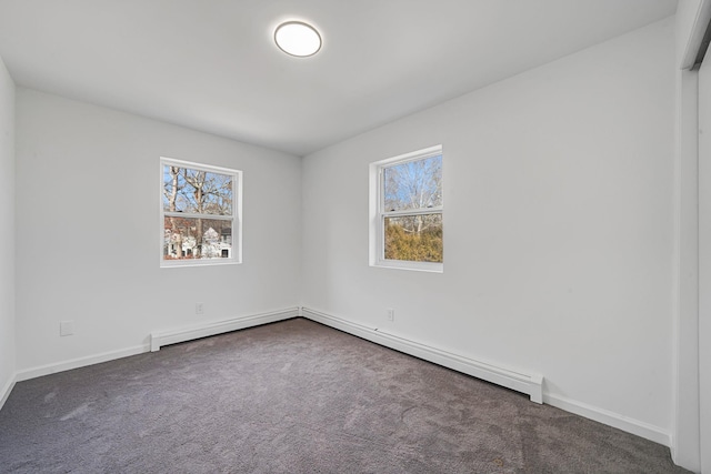 unfurnished room featuring baseboards, dark colored carpet, and a healthy amount of sunlight