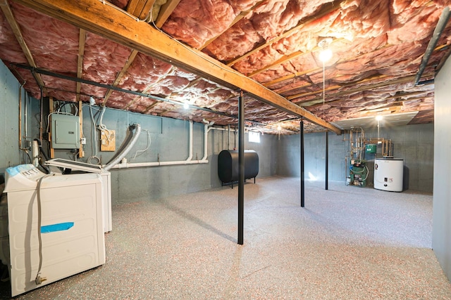 unfinished basement featuring washer and dryer, water heater, electric panel, heating fuel, and a heating unit