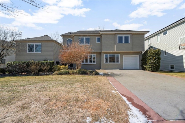 view of front of home featuring an attached garage, driveway, and a front yard