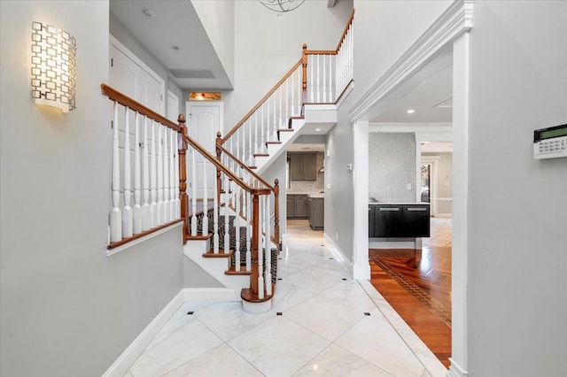 entrance foyer with recessed lighting, a high ceiling, baseboards, and stairs