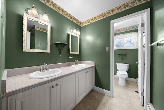 bathroom featuring double vanity, a baseboard radiator, baseboards, and a sink