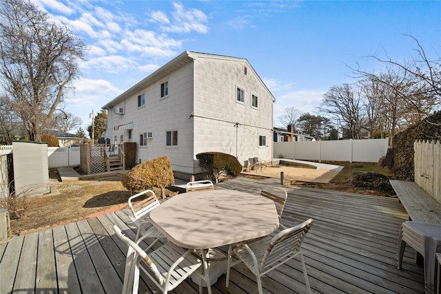 wooden terrace with outdoor dining space, a fenced backyard, and a patio