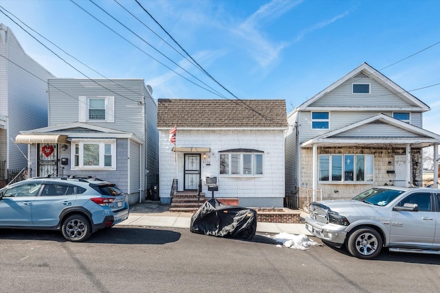 view of front of home featuring a shingled roof and mansard roof