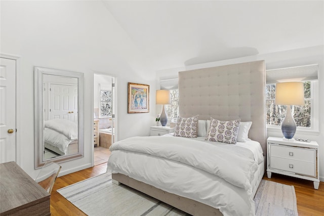 bedroom featuring light wood-style floors and ensuite bath