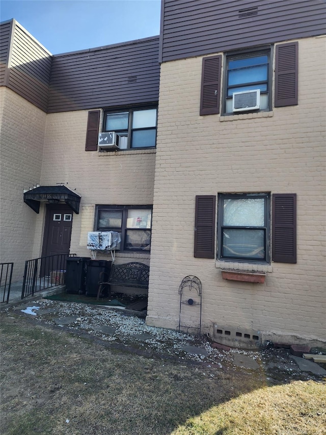 exterior space with cooling unit and brick siding