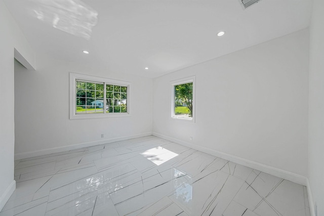 empty room with recessed lighting, marble finish floor, visible vents, and baseboards