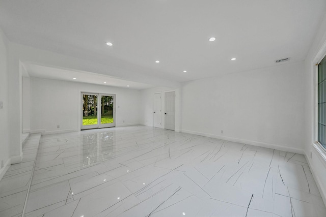 spare room with marble finish floor, baseboards, visible vents, and recessed lighting