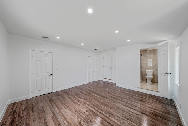 spare room featuring baseboards, dark wood-type flooring, visible vents, and recessed lighting