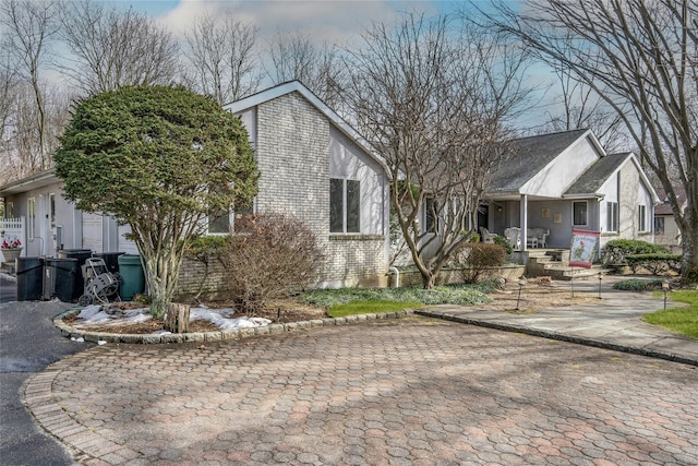 view of front of home with covered porch and brick siding