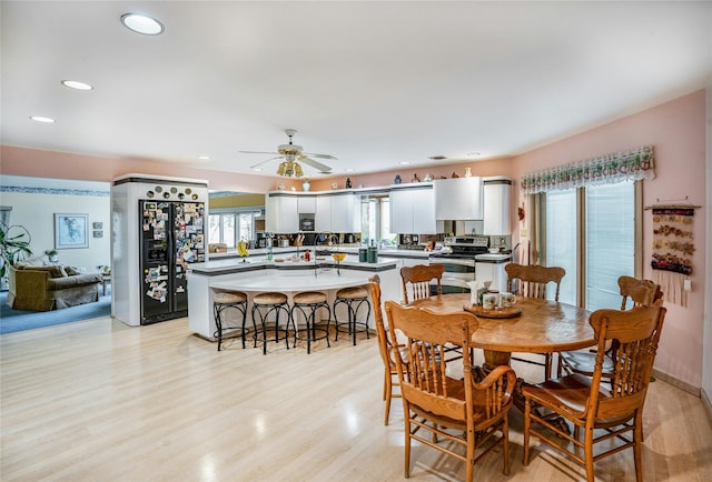 dining room with light wood finished floors, ceiling fan, and recessed lighting