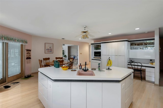 kitchen with light wood-type flooring, a sink, white cabinetry, and modern cabinets