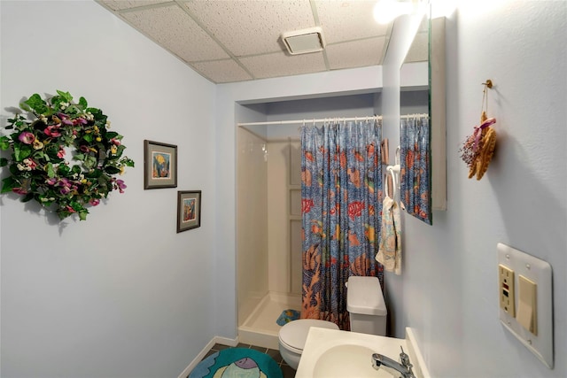 full bath featuring visible vents, toilet, a paneled ceiling, a shower stall, and a sink