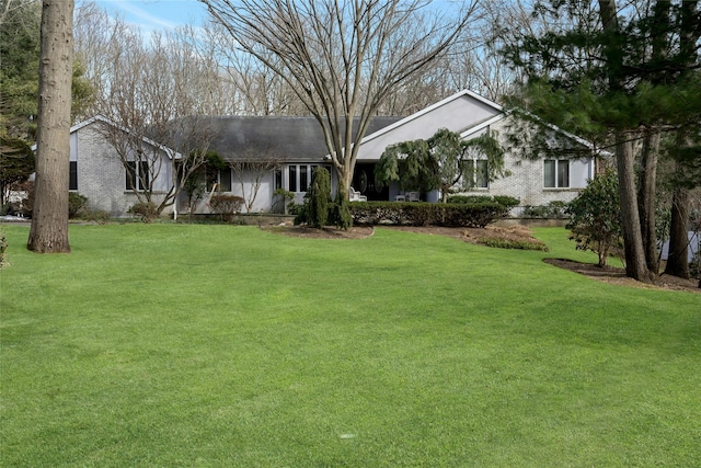 ranch-style house with a front lawn and brick siding