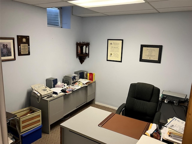 carpeted office space with a paneled ceiling and baseboards