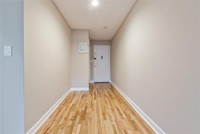 corridor featuring light wood-style floors and baseboards