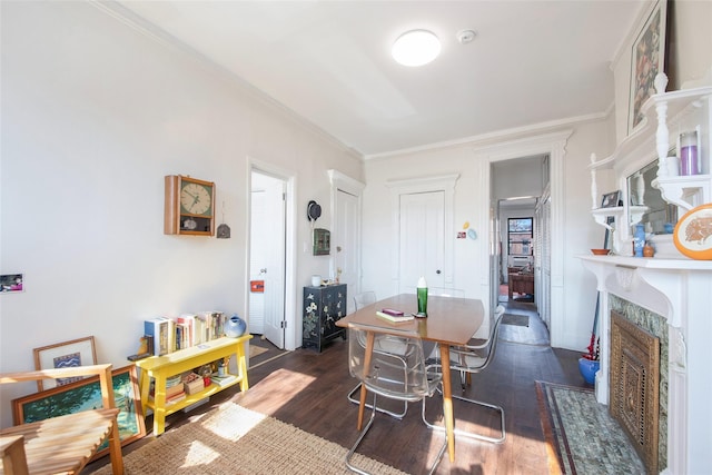 dining area featuring ornamental molding, dark wood finished floors, and a high end fireplace