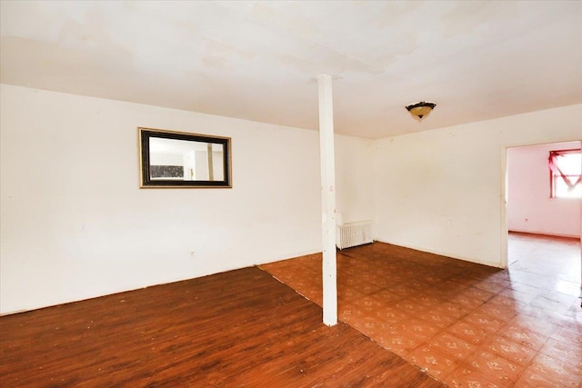 below grade area featuring radiator heating unit and tile patterned floors