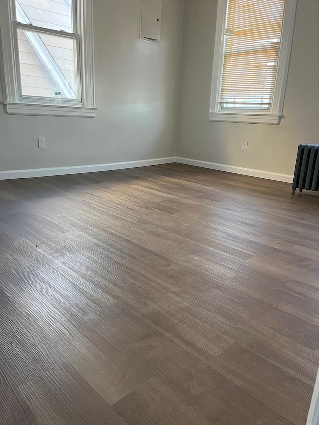 unfurnished room with dark wood-type flooring and baseboards