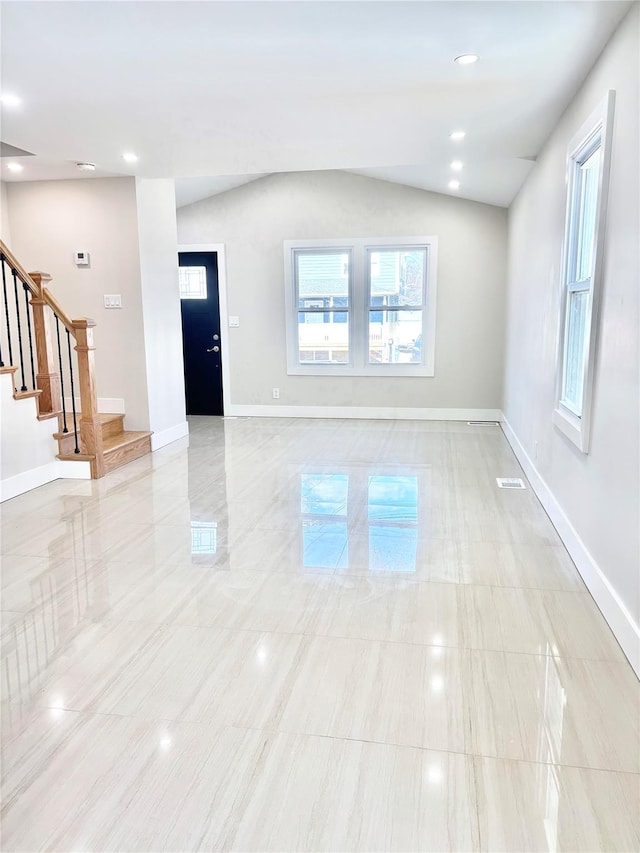 interior space featuring vaulted ceiling, stairway, visible vents, and baseboards