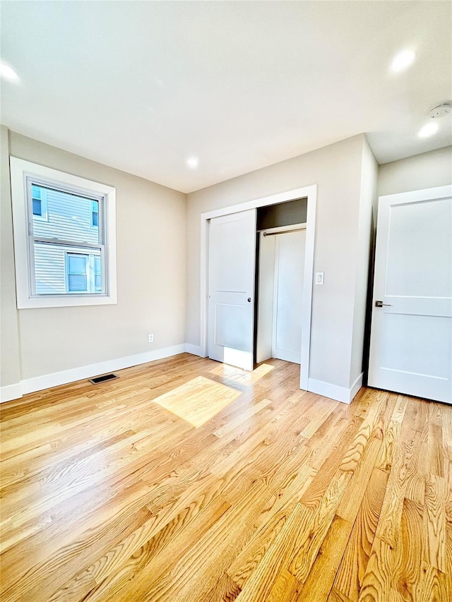 unfurnished bedroom with visible vents, recessed lighting, a closet, light wood finished floors, and baseboards