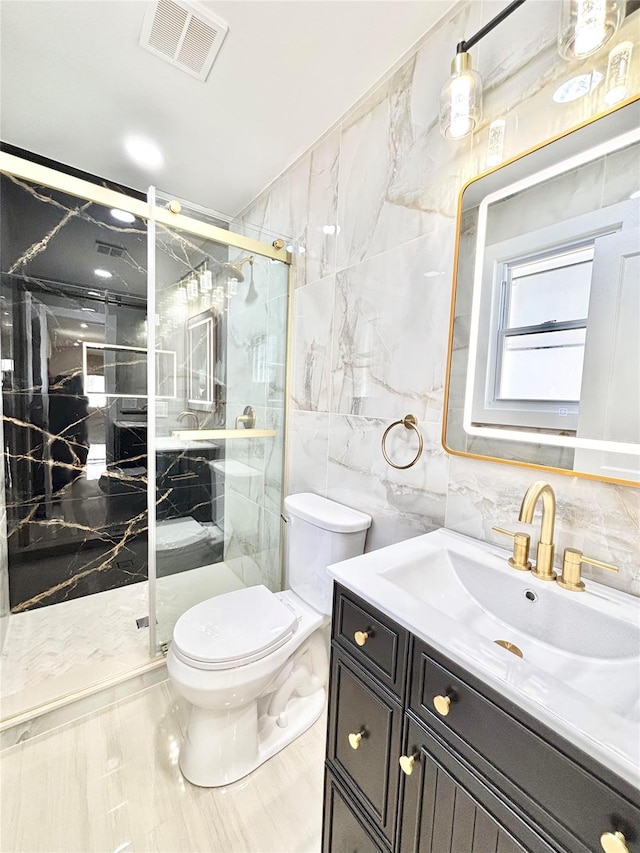 full bath featuring vanity, visible vents, a marble finish shower, tile walls, and toilet