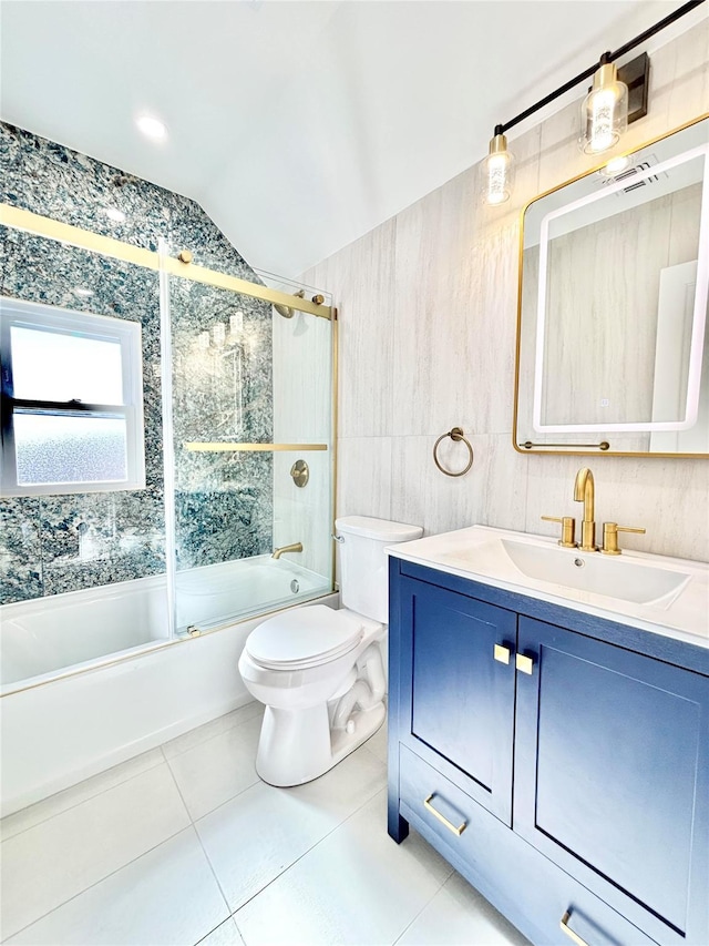 bathroom with toilet, combined bath / shower with glass door, tile walls, tile patterned flooring, and vanity