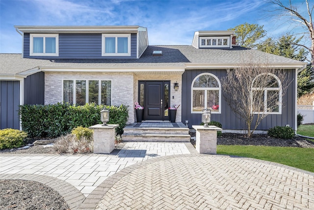 view of front of home featuring board and batten siding and roof with shingles