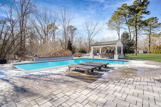 outdoor pool featuring a patio, an outdoor bar, a storage structure, a gazebo, and an outdoor structure