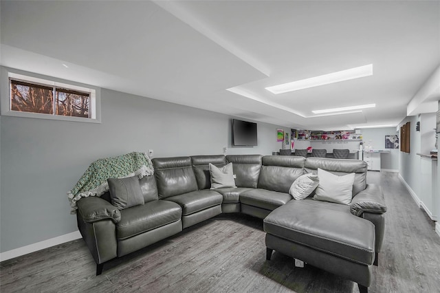 living area featuring baseboards and wood finished floors