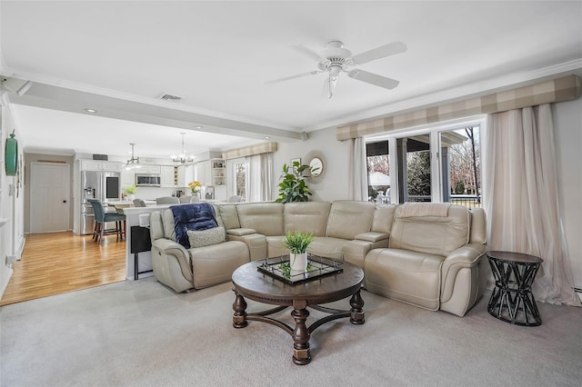 living area featuring light colored carpet, visible vents, crown molding, and ceiling fan with notable chandelier