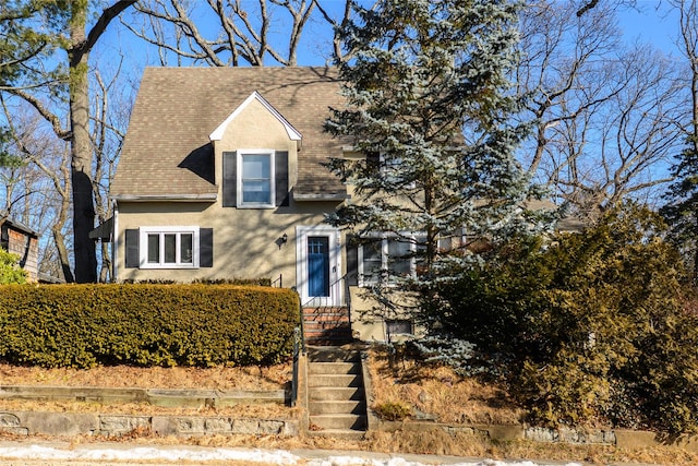 view of front of house with roof with shingles and stucco siding