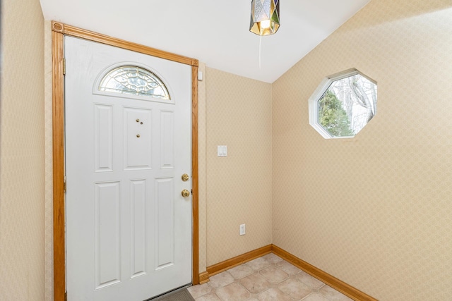 entrance foyer featuring baseboards and wallpapered walls