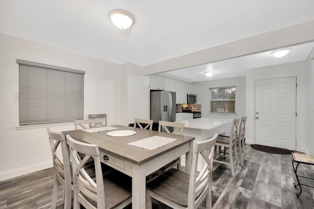 dining space featuring wood finished floors and baseboards