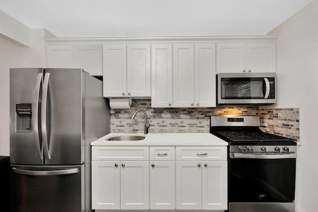 kitchen with appliances with stainless steel finishes, light countertops, white cabinets, and a sink