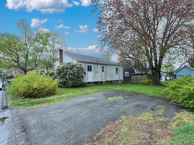 view of front of property featuring a front lawn and a chimney