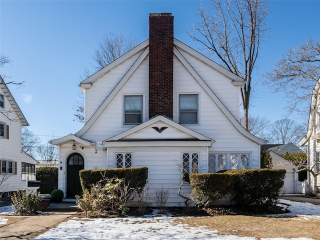 bungalow-style house with a garage and a chimney