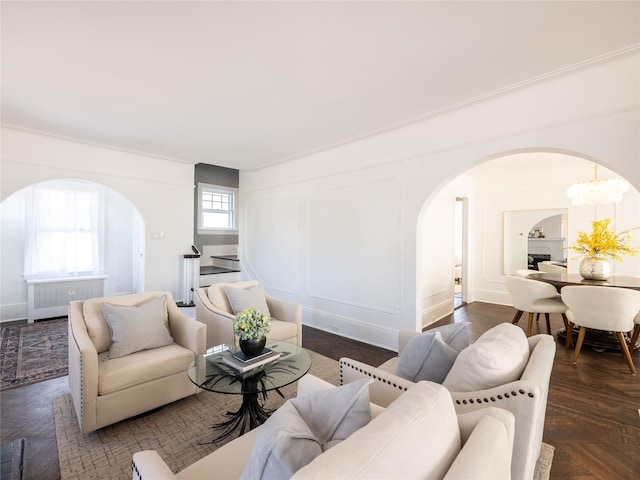 living area with arched walkways, radiator, and a decorative wall